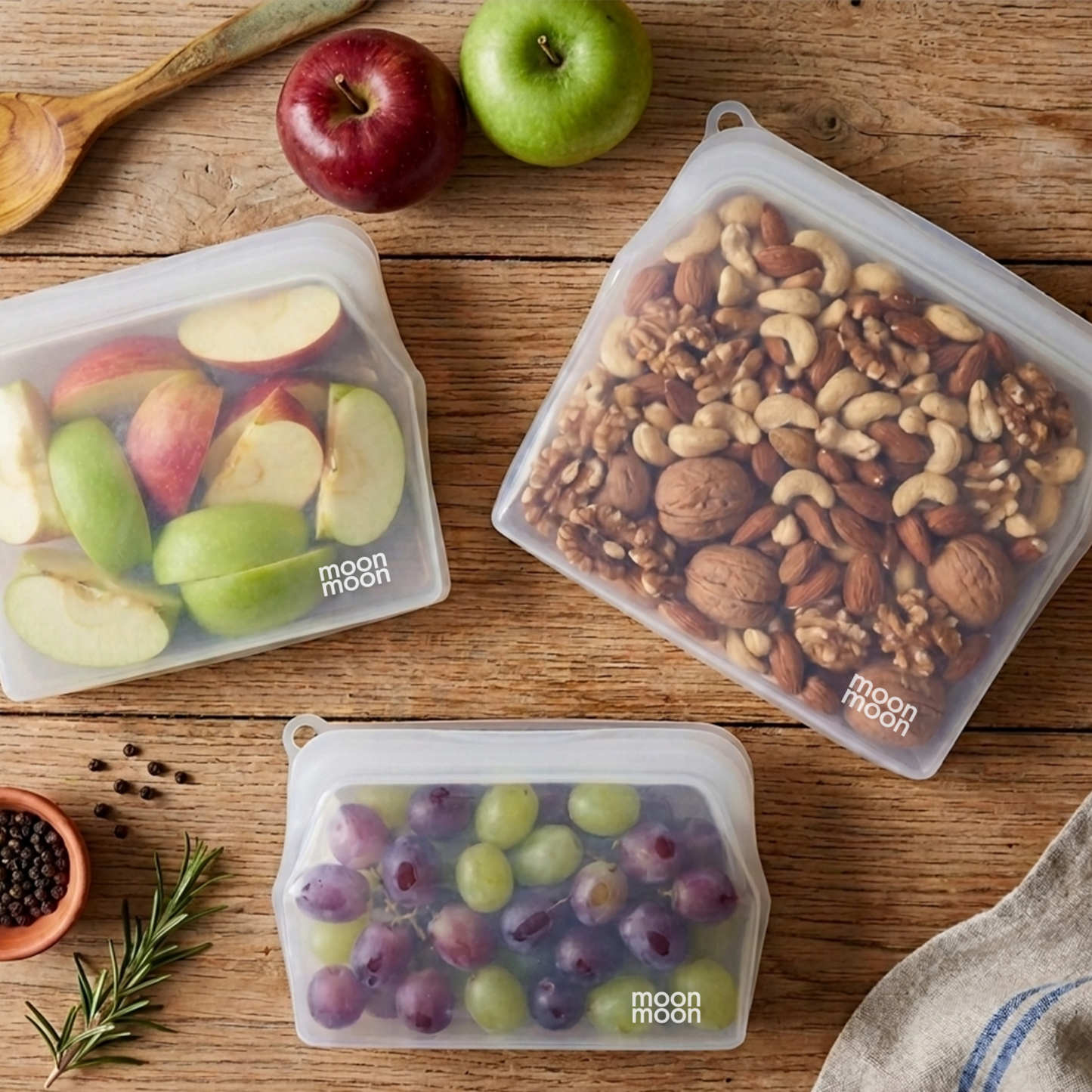 Three reusable silicone storage bags from Moon Moon with fresh fruit and nuts. Food safe, airtight and durable, ensuring food stays fresh and secure.