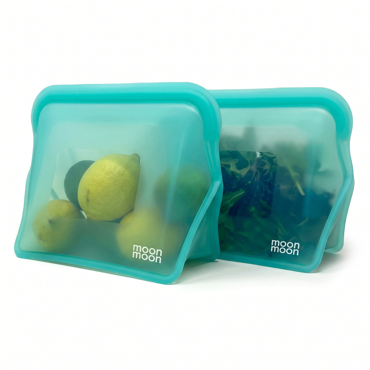 Two large, translucent teal moonmoon reusuable silicone storage bags with wide free standing bases, shown on a clean white background with food items visible through the semi-transparent material.